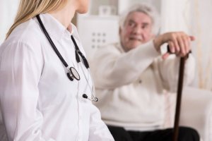 42995283 - young female doctor diagnosing disabled senior man